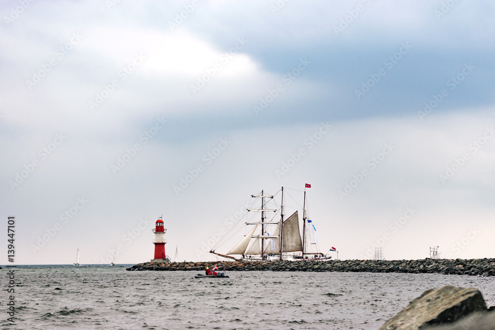 Sailing ship on the sea. Tall Ship and lighthouse Yachting travel.