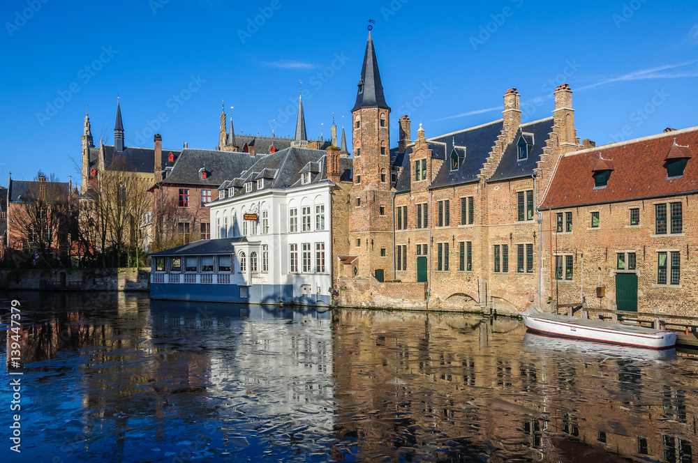 Reflection in the frozen canal in Bruges, Belgium Reflection in the frozen canal in Bruges, Belgium