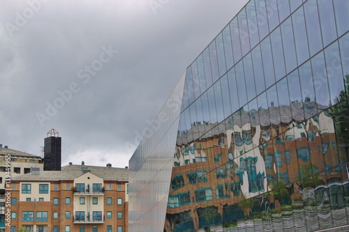 Billede på lærred Norwegian residential buildings mirroring in the glass facade of the Stavanger concert hall