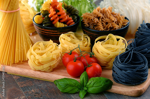 Composition with different sorts of pasta on kitchen table