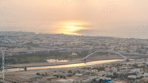 Dubai canal timelapse as seen during an amazing sunset light with boats already crossing it. photo