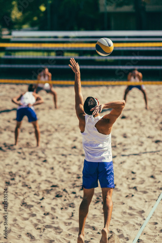 Male team playing beach volleyball