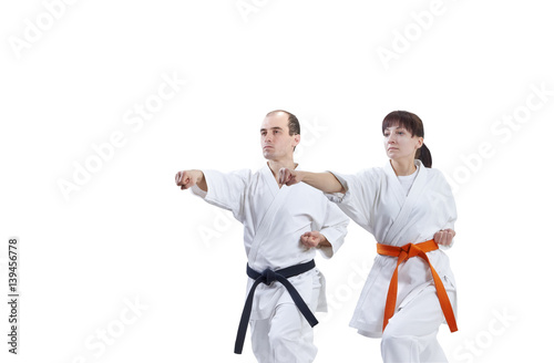 Two athletes in karategi are training punch arm
