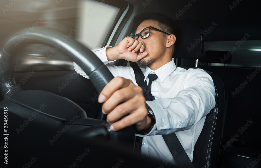 Asian businessman driving driving a car.