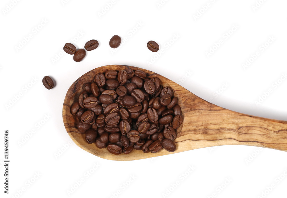 Obraz premium pile coffee beans and wooden spoon isolated on white, top view 