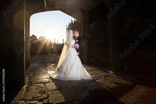 Bride and groom at wedding Day walking Outdoors on spring nature. Bridal couple, Happy Newlywed woman and man embracing in green park. Loving wedding couple outdoor. Bride and groom