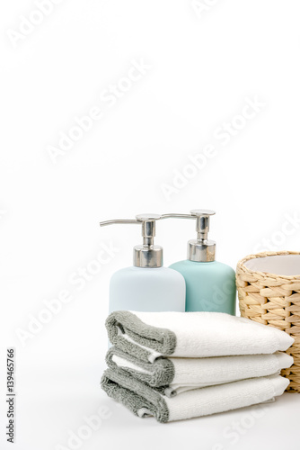 towel, shampoo and liquid soap on the background.