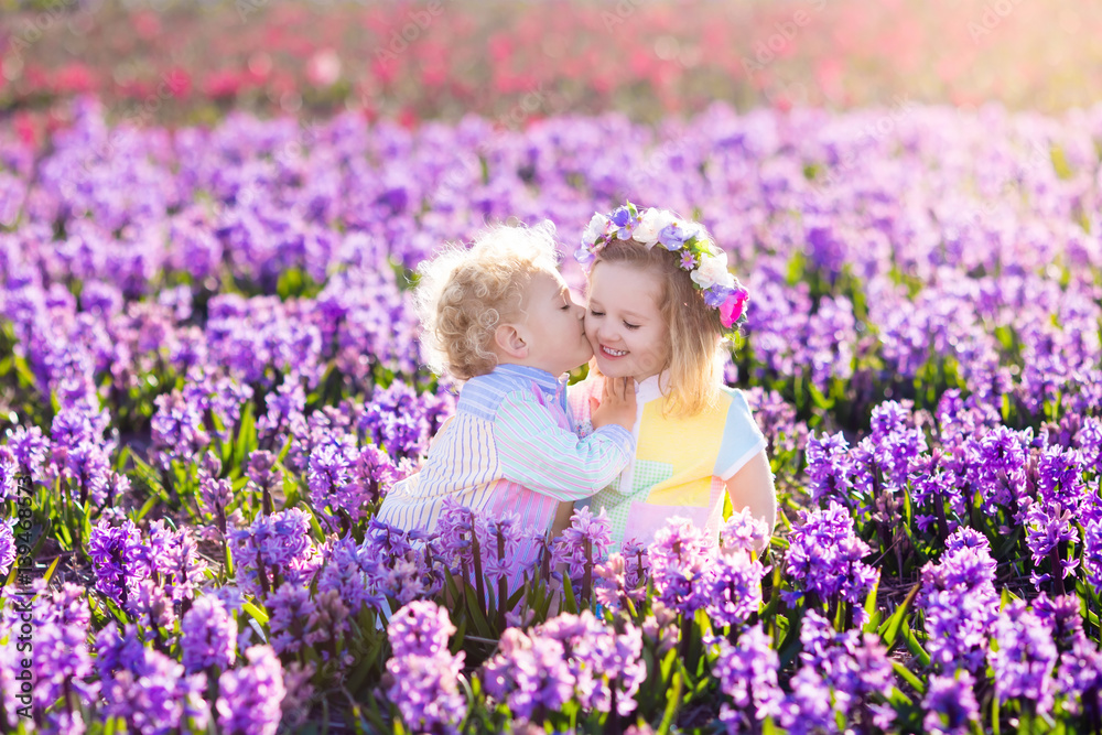 Kids playing in blooming garden with hyacinth flowers