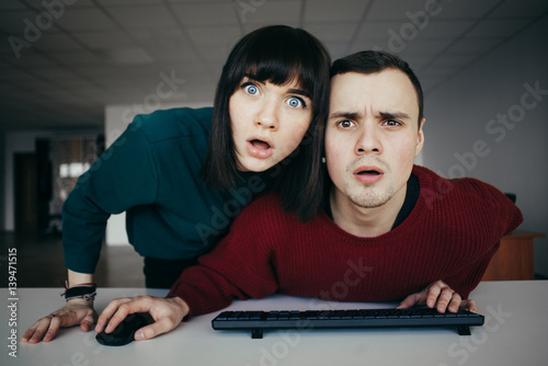 Fotografía Young beautiful people puzzled look in the computer monitor