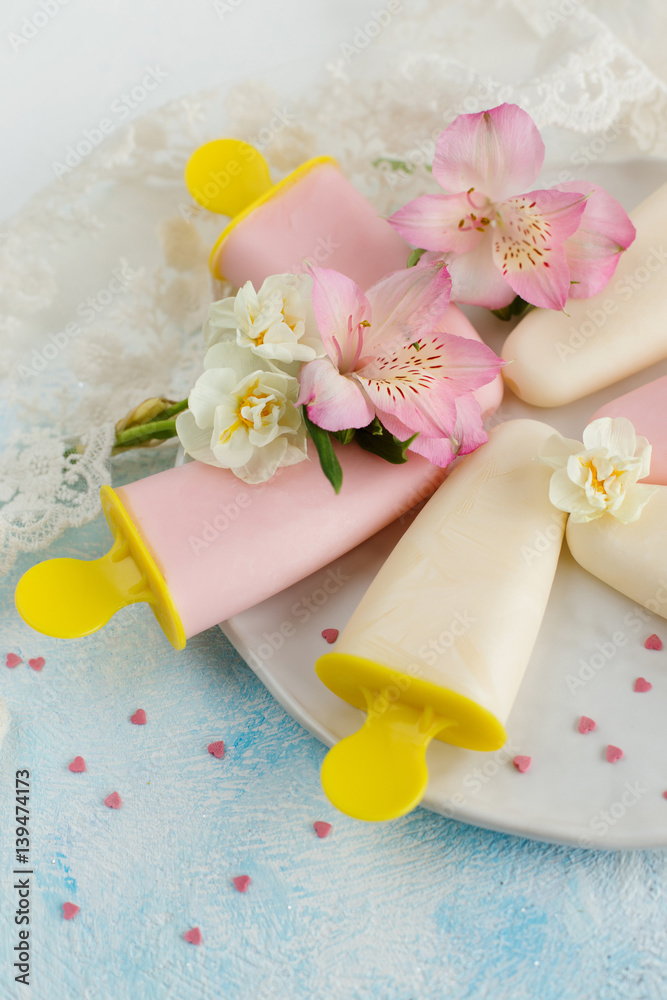 Ice cream with yogurt, decorated with spring flowers on a light background (close-up) Ice cream with yogurt, decorated with spring flowers on a light background (close-up)