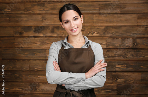 Young woman in apron standi...
