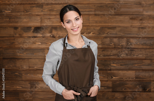 Young woman in apron standi...