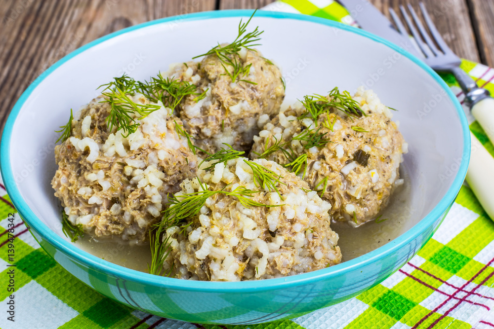 Meatballs meat with the rice grains in a blue ceramic bowl
