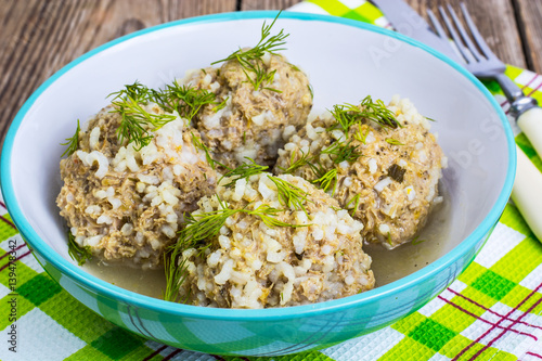 Meatballs meat with the rice grains in a blue ceramic bowl
