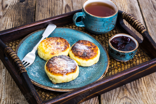 Pancakes with honey on vintage bowl on wooden tray photo