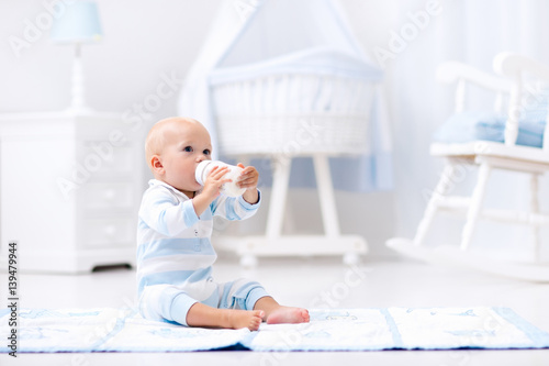 Wallpaper Mural Baby boy drinking milk in sunny nursery Torontodigital.ca