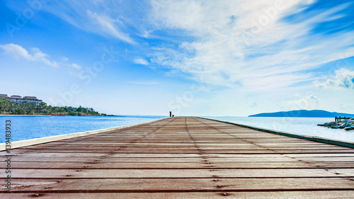 Wooden plank pier with seascape and bright blue sky