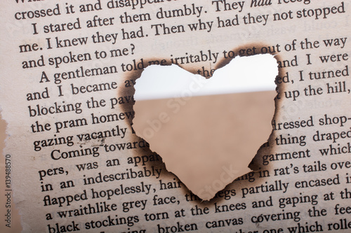 Heart shaped burnt out of texted  paper photo