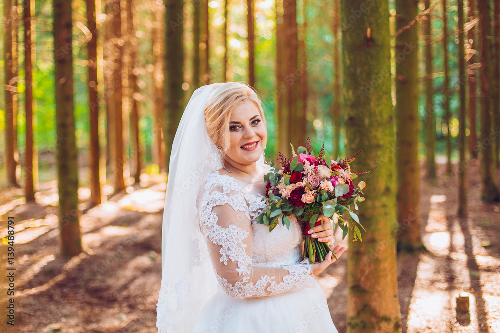 Happy young bride in a pine forest, to whirl in the dance, flowing white wedding dress Happy young bride in a pine forest, to whirl in the dance, flowing white wedding dress
