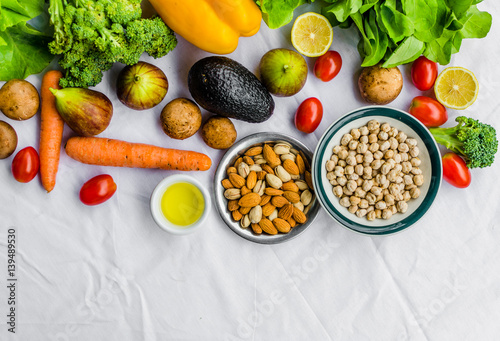 Flat lay photo of fresh fruit and vegetables, grains, and nuts on a white background. Concept of cooking and eating healthy food, fitness, vegetarian and vegan, and lifestyle.