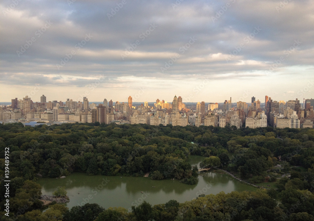 The Lake in Central Park, New York, viewed from a tall building on the west side of the park.Aerial view of Central Park, sun setting on  Upper East Side apartment buildings.Overview of Central Park.