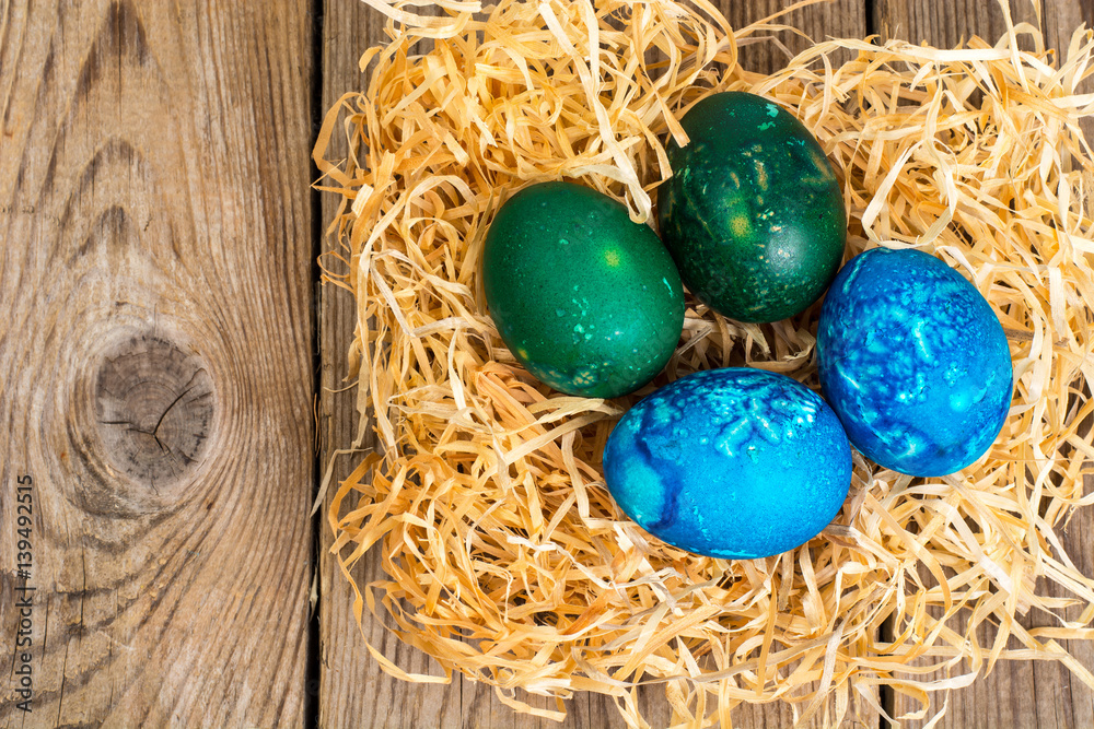 Easter colored eggs, straw, flowers Easter colored eggs, straw, flowers
