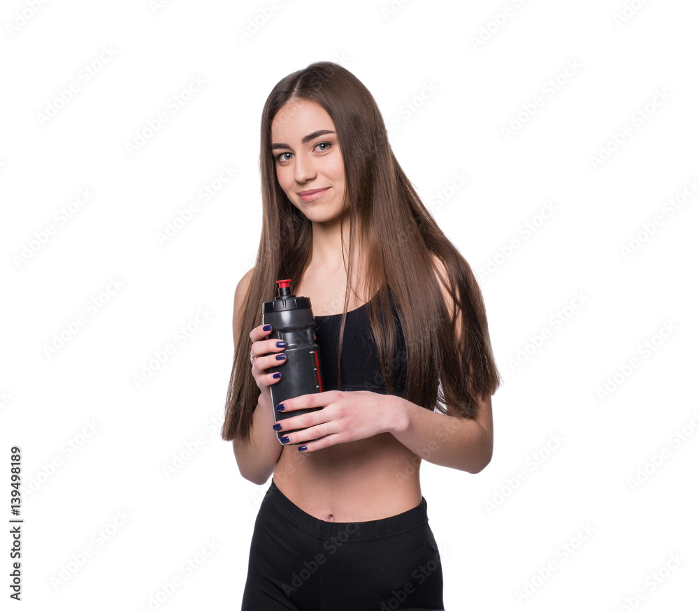 Portrait of smiling young sporty woman with a bottle of water posing in studio isolated on white background. Portrait of smiling young sporty woman with a bottle of water posing in studio isolated on white background.