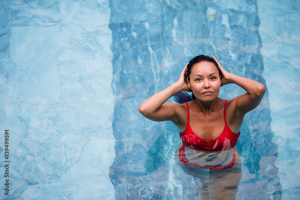 Enjoying vacation. Smiling beautiful young woman in swimming pool.