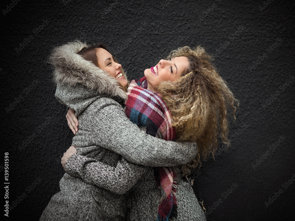Meeting of two young girlfriends embracing happy to see each other Meeting of two young girlfriends embracing happy to see each other