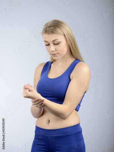 Beautiful fit female fitness model is checking heart biting rate.