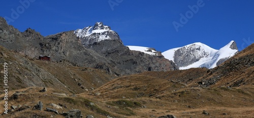 View from lake Stellisee towards Fluhalp. Peaks of mount Strahlhorn and Adlerhorn. Autumn day in Zermatt. photo