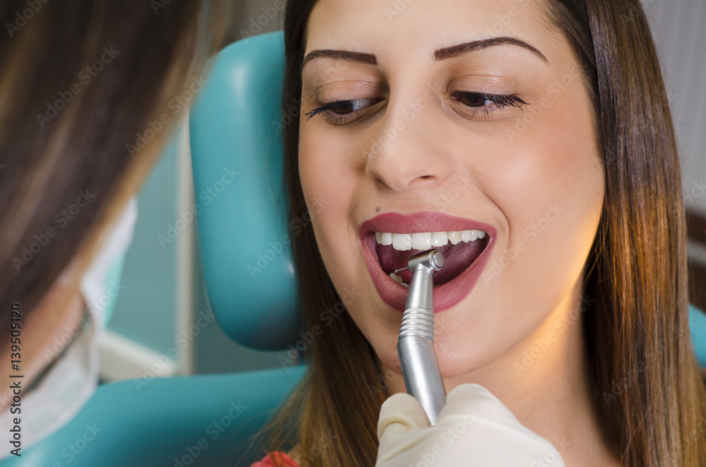 Dentist drilling teeth to young pretty woman Stock Photo Adobe Stock