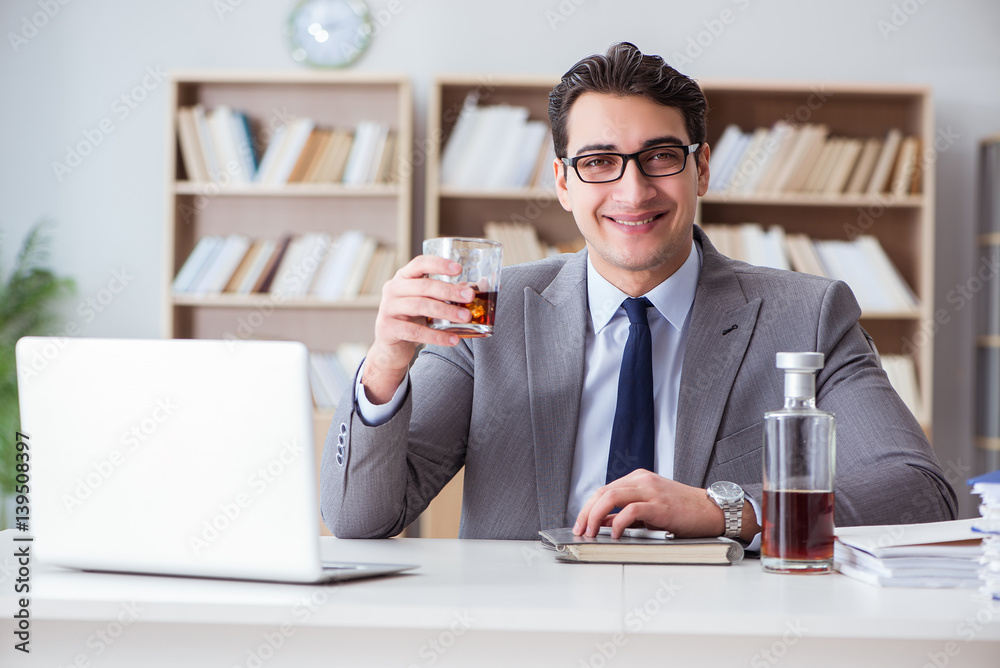 Businessman drinking in the office Businessman drinking in the office