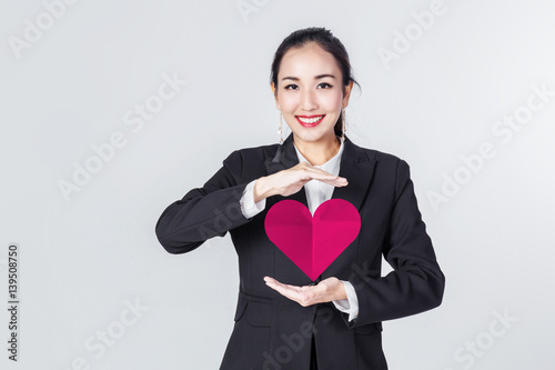 asian business woman smile and show red heart paper love concept