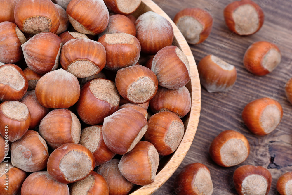 Many hazelnuts in a bamboo bowl on table Many hazelnuts in a bamboo bowl on table
