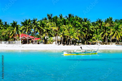 Rural tropical white sand beach with coconut palms