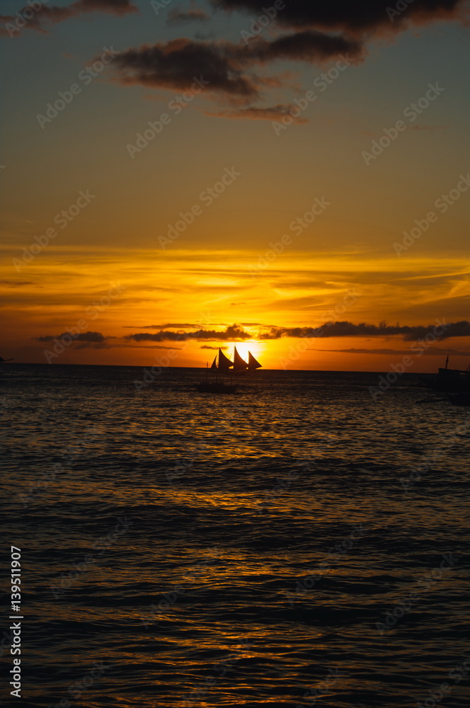 Beautiful golden sunset over fishing boats on the sea