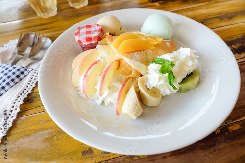 crepe with fresh fruit on wooden table