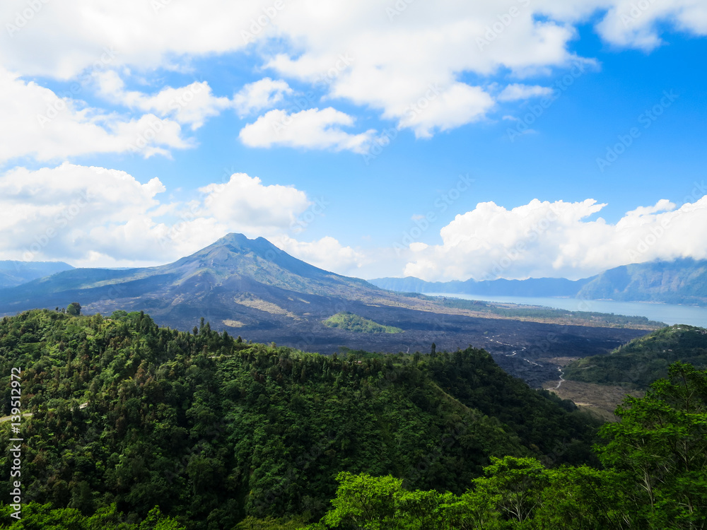 Volcano mountain view with lake, lush green forest, blue sky and white cloud