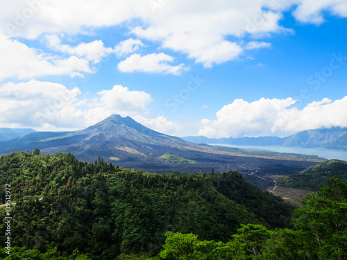 Volcano mountain view with lake  lush green forest  blue sky and white cloud