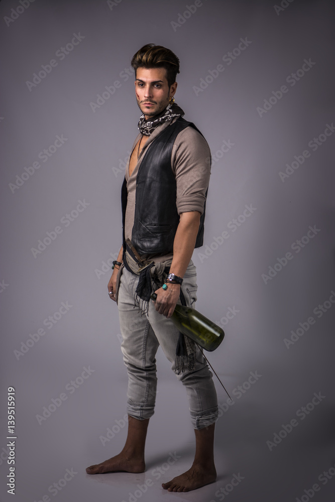 Good Looking Young Man in Pirate Fashion Outfit on Gray Background. Captured in Studio. Good Looking Young Man in Pirate Fashion Outfit on Gray Background. Captured in Studio.