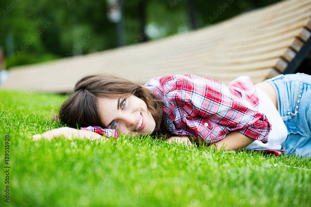 Beautiful smiling woman lying on green grass Beautiful smiling woman lying on green grass