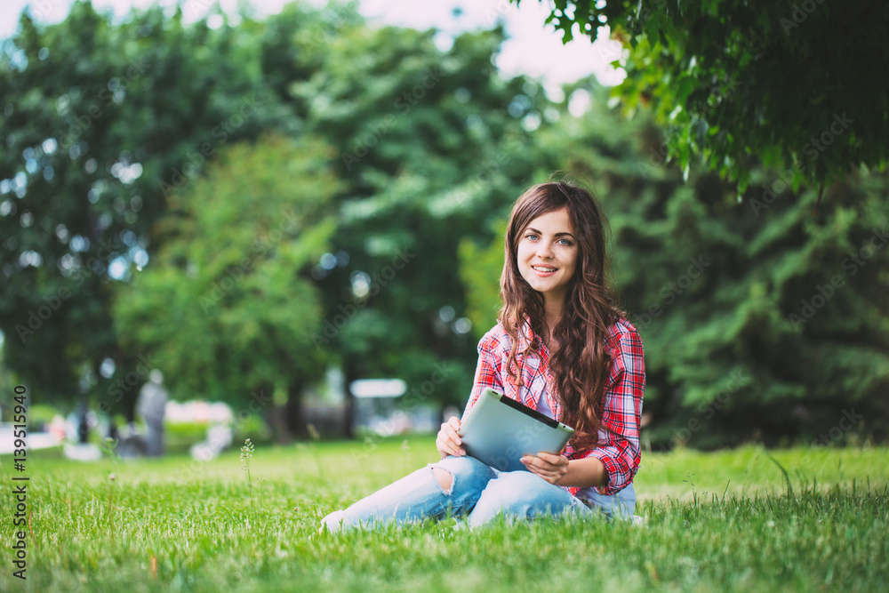 Young beautiful smiling woman with touchpad on outdoors.