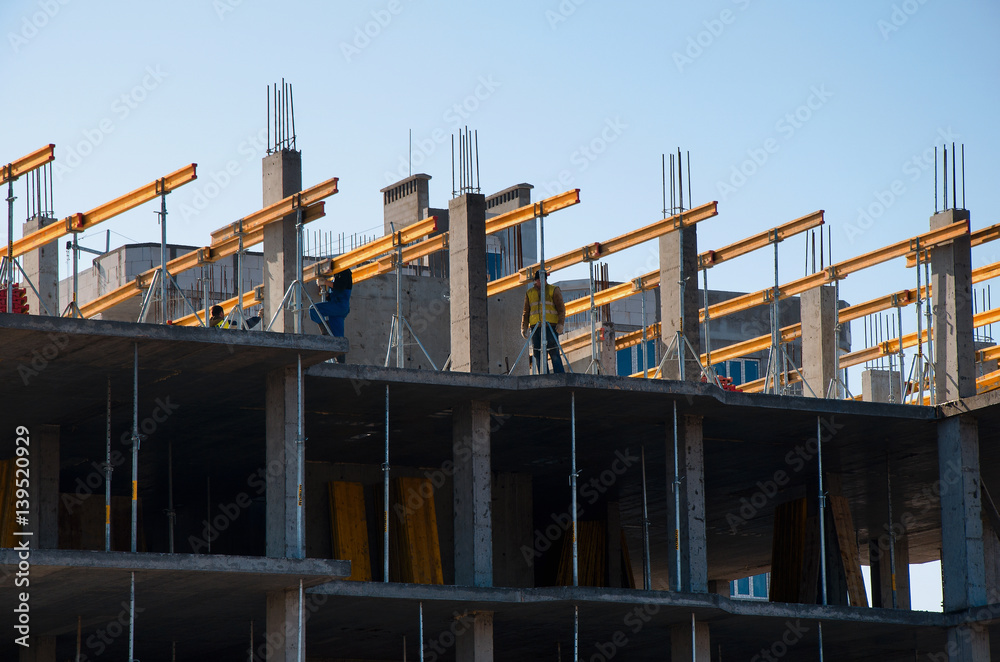 Fototapeta premium Construction workers installing mounting horizontal formwork on the building construction site.