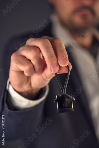 Real estate broker or agent offering house shaped key ring