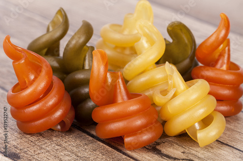 Spiral pasta trottole tricolore on wooden plank photo