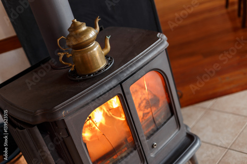Kettle heats up on the fireplace in the house
