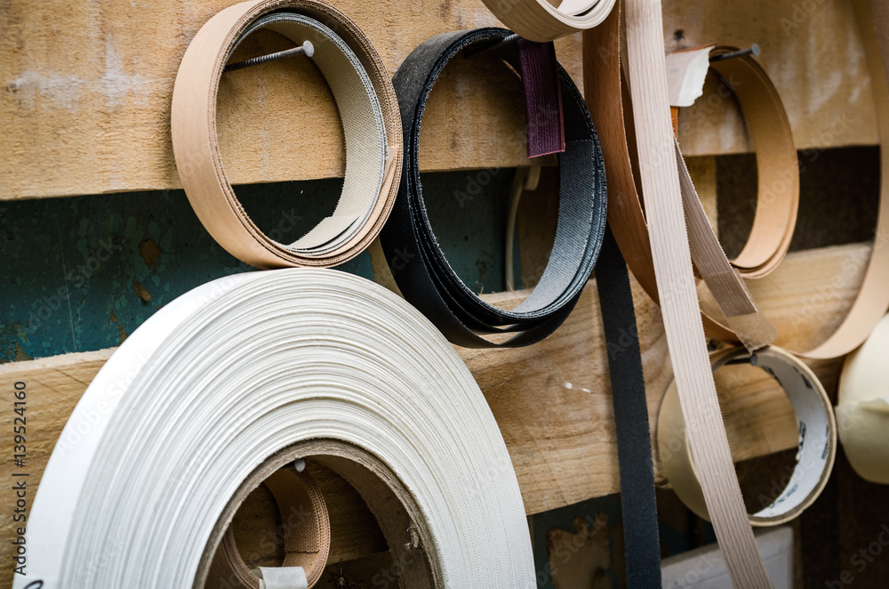 Ribbon trim chipboard on a wooden bench, furniture repair. Close-up background Ribbon trim chipboard on a wooden bench, furniture repair. Close-up background