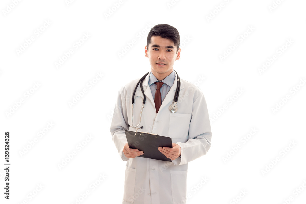 portrait of pretty young brunette male doctor in uniform with stethoscope posing isolated on white background portrait of pretty young brunette male doctor in uniform with stethoscope posing isolated on white background