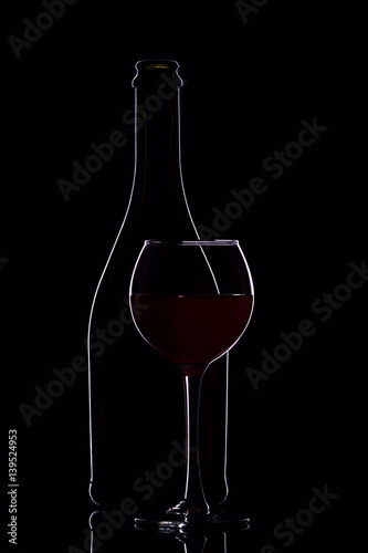 Wine glasses with wine bottle on a black background, minimalism, silhouette